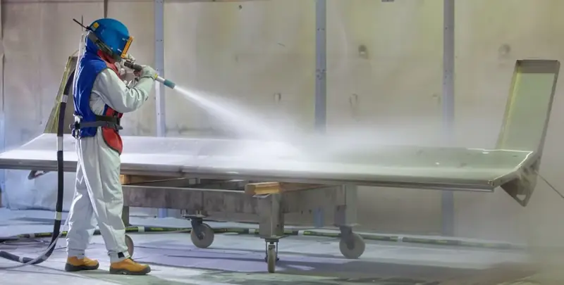 Technician dustless blasting a panel
